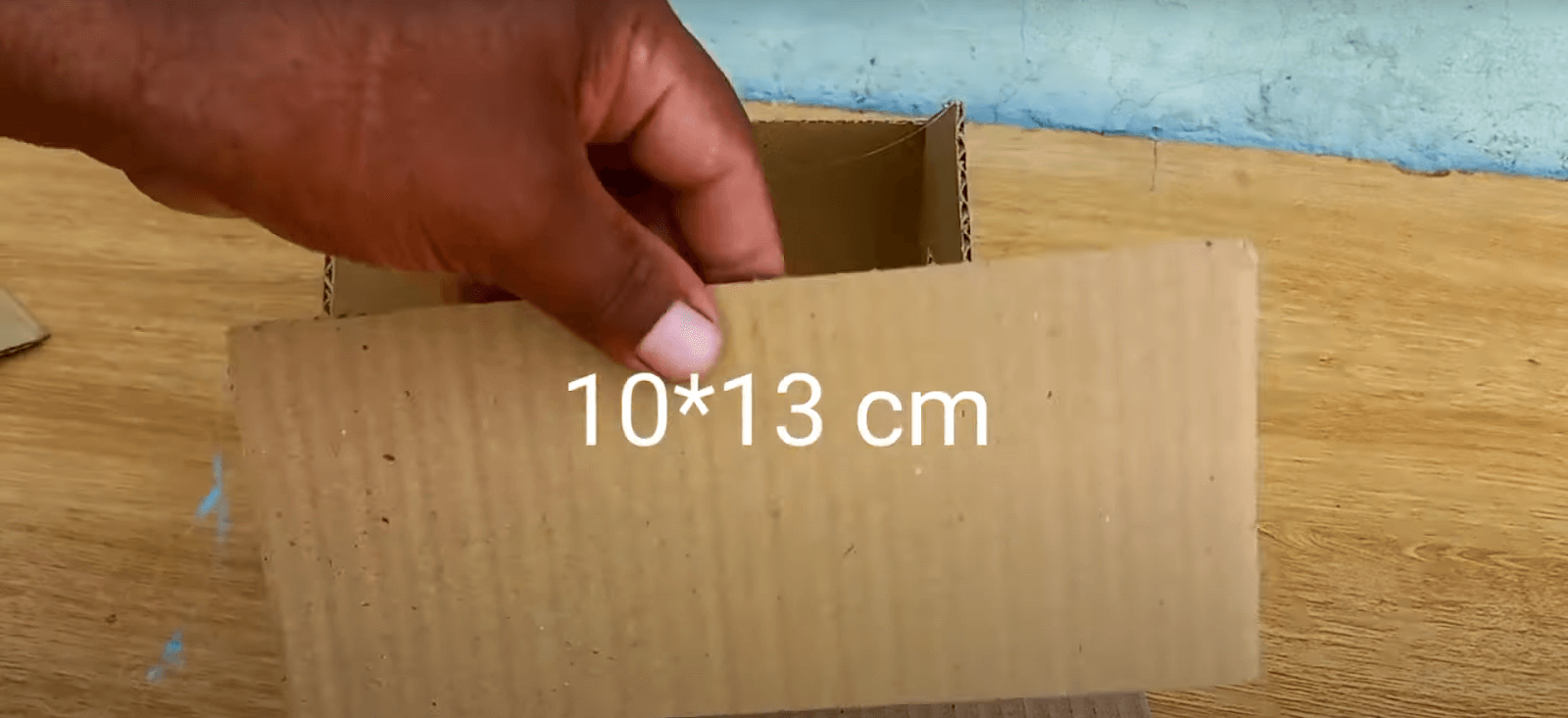 Cắt 2 miếng bìa có kích thước 10*13cm để làm phần mái cho nhà bằng giấy cứng